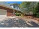Charming brick home with attached garage and large driveway surrounded by lush trees at 423 Morgan Falls Chase, Canton, GA 30114