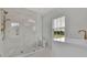 Bright bathroom with glass shower and a sink next to a window at 4812 Moonview Ln # 4, Sugar Hill, GA 30518