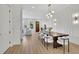 Bright dining area features long wooden table with white cushioned chairs, stylish lighting, and decorative wall panels at 4812 Moonview Ln # 4, Sugar Hill, GA 30518