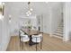 Dining room with modern light fixture, seating for eight, and an open concept to the kitchen at 4812 Moonview Ln # 4, Sugar Hill, GA 30518