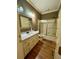 A classic bathroom has hardwood floors, white cabinetry, and gold-trimmed fixtures at 1049 Panola Rd, Ellenwood, GA 30294