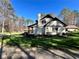 Charming home exterior with well-maintained lawn, lush greenery, and mature trees under clear blue sky at 1049 Panola Rd, Ellenwood, GA 30294