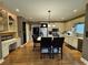 A well-lit kitchen features stainless appliances, hardwood floors, and an island with seating and decorative touches at 1049 Panola Rd, Ellenwood, GA 30294