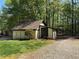 Outbuilding with neutral siding and dark trim with grassy area and gravel driveway at 1049 Panola Rd, Ellenwood, GA 30294
