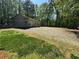 Outbuilding with plenty of gravel parking area and adjacent grassy area at 1049 Panola Rd, Ellenwood, GA 30294