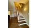 Elegant staircase with hardwood treads, a white railing, complemented by a hardwood floor, and decorative wall sconces at 1049 Panola Rd, Ellenwood, GA 30294