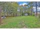 Large grassy backyard with mature trees and storage shed, perfect for outdoor activities at 1531 Piedmont Ne Rd, Marietta, GA 30066