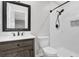 Bathroom featuring modern sink, marble countertop, a dark framed mirror, and tiled shower at 1531 Piedmont Ne Rd, Marietta, GA 30066