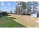 Large backyard with mature trees, lawn, and outbuildings at 2003 Graystone Pkwy, Grayson, GA 30017