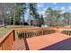 View of the stained, wooden deck with railing, with natural landscaping and a shed visible in the background at 2003 Graystone Pkwy, Grayson, GA 30017