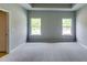 This bedroom features a tray ceiling, neutral walls, plush carpeting, and natural light from the double-hung windows at 3855 Shelleydale Dr, Powder Springs, GA 30127