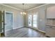 Bright dining area with French doors, chandelier, and modern flooring, perfect for Gathering meals and entertaining at 3855 Shelleydale Dr, Powder Springs, GA 30127