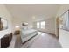 A serene bedroom showcasing natural light from large windows, complemented by neutral tones and simple decor at 7763 Sudbury Cir, Covington, GA 30014