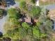 Aerial view shows the roof of the home surrounded by lush trees in a neighborhood setting at 8885 N Mount Dr, Johns Creek, GA 30022