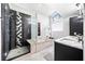 Bathroom features a glass walk-in shower, tub, and stylish tile work at 8885 N Mount Dr, Johns Creek, GA 30022