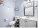 Bathroom features a framed mirror above a white vanity with storage and a toilet at 8885 N Mount Dr, Johns Creek, GA 30022