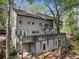 Multi-story home with balconies, wood siding, and surrounded by lush greenery at 8885 N Mount Dr, Johns Creek, GA 30022
