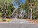 Exterior view of house with attached garage and driveway. The house is surrounded by mature trees at 8885 N Mount Dr, Johns Creek, GA 30022