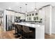 Modern kitchen featuring an island with seating, stainless steel appliances, and stylish pendant lighting at 8885 N Mount Dr, Johns Creek, GA 30022