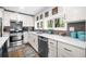 Modern kitchen with white cabinets, stainless steel appliances, and gray backsplash tiles at 8885 N Mount Dr, Johns Creek, GA 30022