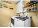 Functional laundry room featuring a washer, dryer, and shelving for storage at 8885 N Mount Dr, Johns Creek, GA 30022
