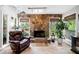 Cozy living room featuring a stone fireplace, large windows, and comfortable leather armchair at 8885 N Mount Dr, Johns Creek, GA 30022