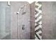 Updated tiled shower features glass shelves and a modern shower head at 8885 N Mount Dr, Johns Creek, GA 30022