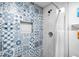Stylish shower featuring a blue tiled wall, shower curtain, and built-in niche at 8885 N Mount Dr, Johns Creek, GA 30022
