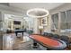 Spacious game room featuring a billiards table, poker table, stone fireplace, and stylish lighting fixtures at 115 Batten Board Way Way, Woodstock, GA 30189