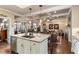 Open concept kitchen with granite countertops island, leading into a living room with tray ceilings and hardwood floors at 115 Batten Board Way Way, Woodstock, GA 30189