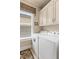 Bright laundry room with washer, dryer, and ample storage cabinets near a window at 115 Batten Board Way Way, Woodstock, GA 30189