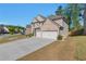 Side view of a two-story brick home with an attached two-car garage and a spacious driveway at 2021 Adam Acres Dr, Lawrenceville, GA 30043