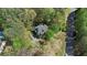 Aerial view of a house nestled among lush trees, complemented by a nearby pool and a winding street at 104 Kremer Falls Trce, Canton, GA 30114