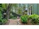 Lush backyard with stone pathway, mature trees and a glimpse of the covered porch, a perfect outdoor space at 104 Kremer Falls Trce, Canton, GA 30114