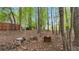 A backyard fire pit and wood stack surrounded by lush trees add rustic charm at 104 Kremer Falls Trce, Canton, GA 30114