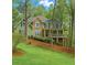 Charming two-story home with a mix of green siding and stone, complemented by a beautifully landscaped front yard at 104 Kremer Falls Trce, Canton, GA 30114