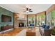 Cozy living room featuring a stone fireplace, hardwood floors, and large windows offering scenic views at 104 Kremer Falls Trce, Canton, GA 30114