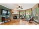 Living room with a stone fireplace, hardwood floors, and lots of natural light from the large windows at 104 Kremer Falls Trce, Canton, GA 30114