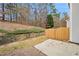 Backyard patio with wooden fence and retaining wall against wooded area at 2991 Greyhawk Ln, Cumming, GA 30040