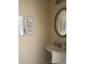 Bathroom sink with elegant round mirror and decorative wall art create a comforting design at 2991 Greyhawk Ln, Cumming, GA 30040