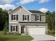 Charming two-story home with gray siding, black shutters, and an attached two-car garage at 7771 Sudbury Cir, Covington, GA 30014