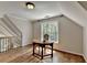Sunlit attic space with hardwood flooring and a desk with a window view at 9770 Rod Rd, Alpharetta, GA 30022