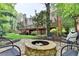 Landscaped backyard features a stone fire pit and mature trees at 9770 Rod Rd, Alpharetta, GA 30022