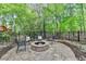 Outdoor fire pit area with stone pavers and seating surrounded by lush trees at 9770 Rod Rd, Alpharetta, GA 30022