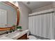 Cozy bathroom with a granite vanity and shower with a neutral-toned shower curtain at 9770 Rod Rd, Alpharetta, GA 30022