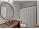 Bathroom features a unique sink, bronze fixtures, and a shower with a curtain, blending style and function at 9770 Rod Rd, Alpharetta, GA 30022