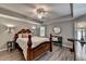 Elegant bedroom with a tray ceiling, wood floors, and a cozy seating area at 9770 Rod Rd, Alpharetta, GA 30022