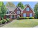 Charming brick home with manicured lawn, mature trees, and blue shutters at 9770 Rod Rd, Alpharetta, GA 30022