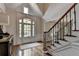 Welcoming foyer with hardwood floors, staircase with wrought iron spindles, and ample natural light at 9770 Rod Rd, Alpharetta, GA 30022