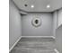 Modern hallway with gray wood floors and a decorative sunburst mirror at 9770 Rod Rd, Alpharetta, GA 30022